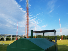 View of TV broadcast tower in foreground with 3 AM towers in the background